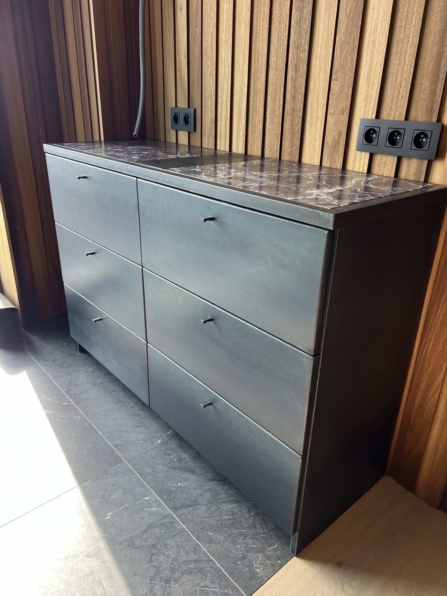 Detail of the blackened steel drawer fronts with marble top