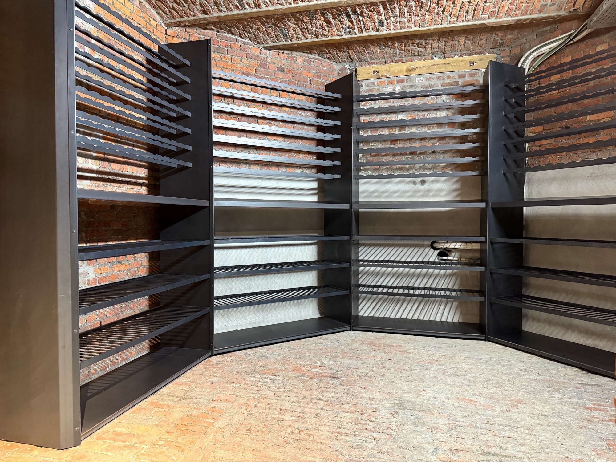 Full view of the hexagonal wine cellar with blackened steel racks