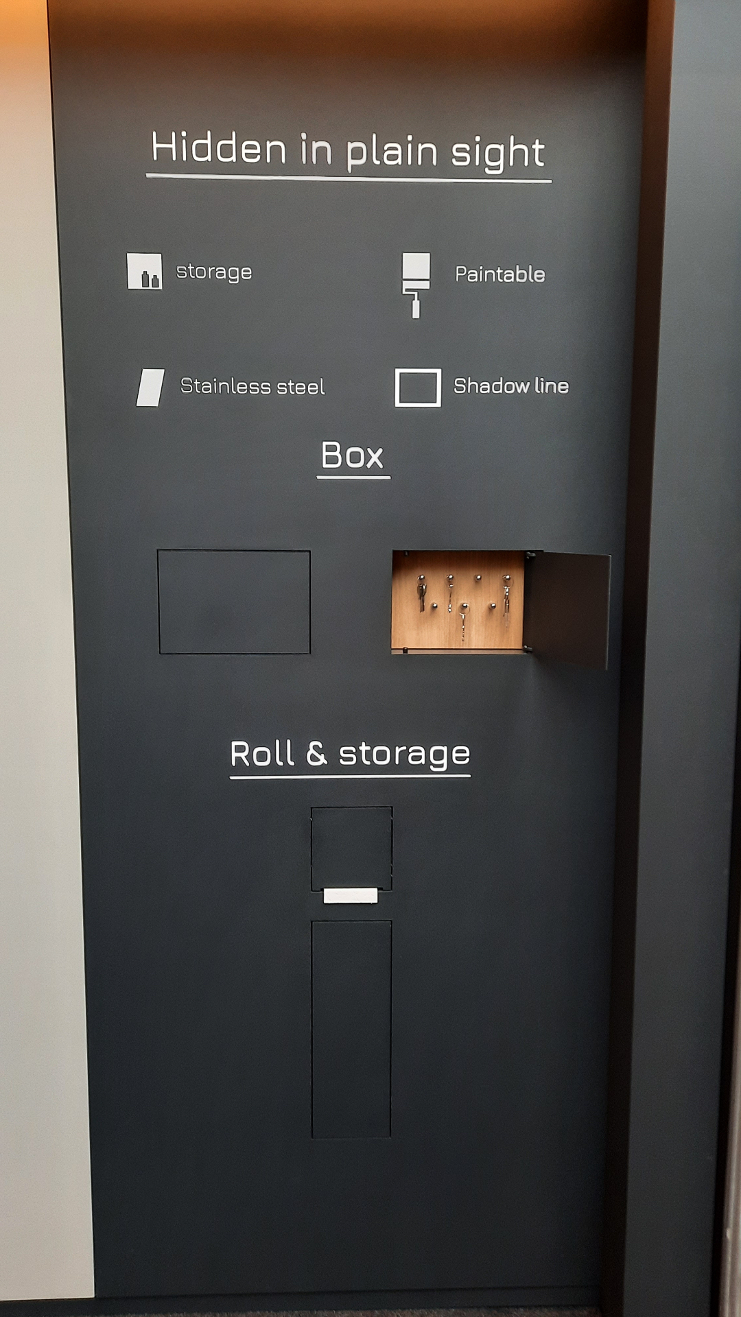 Detail of the HIDN stand wall showing Box and Roll & storage cut-outs with the 'Hidden in plain sight' wording