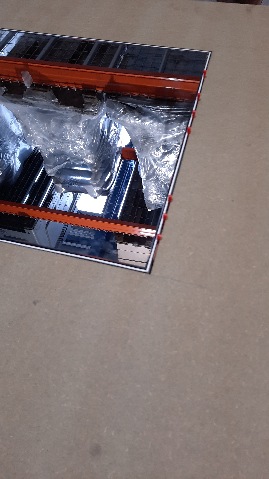 HIDN mirror mounted into the fair stand wall, reflecting the warehouse ceiling