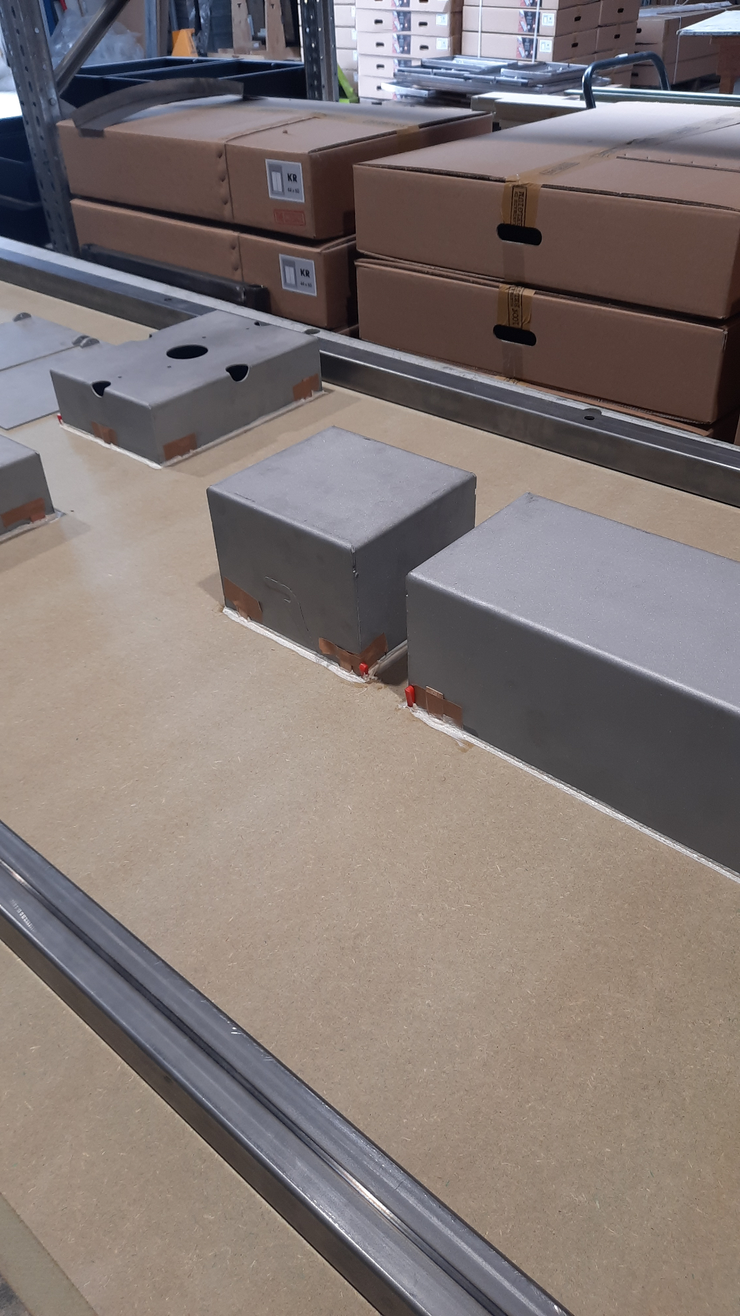 Painted HIDN box and roll & storage units lined up on the assembly bench